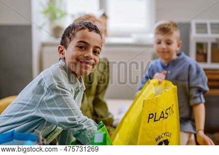 Children Separating Rubish In To Three Bins.