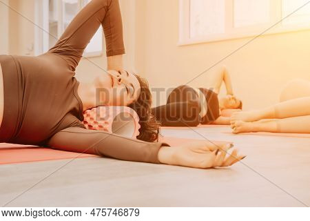 Middle Aged Well Looking Women, Performing Fascia Exercises On The Floor Using A Massage Foam Roller