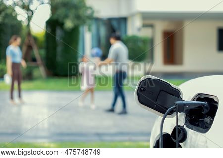 Focus Ev Charger Connected With Ev Car At Outdoor Home Charging Station With Blur Progressive Family