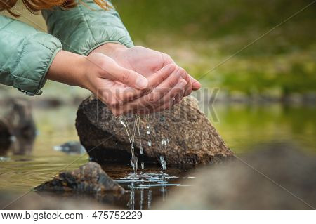 Close-up Of A Womans Hand Pouring Water From Her Palms While Trying To Drink From A Clean Water Sour