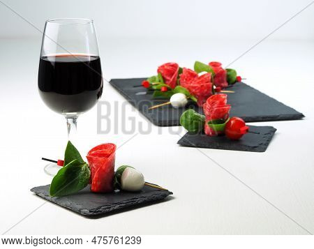 Сanape With Salami, Tomatoes And Mozzarella. Beautifully Served Appetizer On Skewers And A Glass Of 