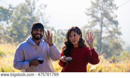 Couple Drink Coffee In Morning Time. Young Couple Holding Mugs While Enjoying The View Of Nature. \r