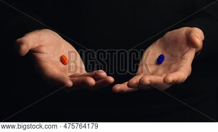 Studio Shot Male Hands Show Red Pill And Blue Pill Isolated On Black Background. Concept Of Making R