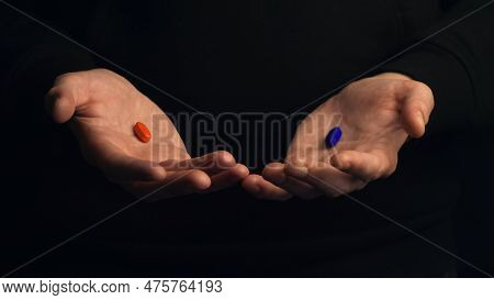 Studio Shot Male Hands Show Red Pill And Blue Pill Isolated On Black Background. Concept Of Making R