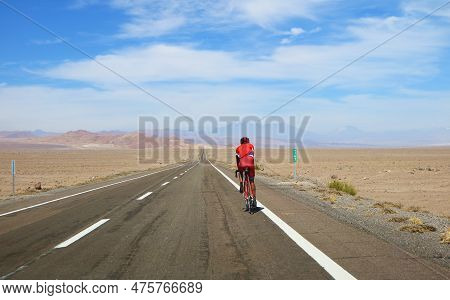 Person Cycling On The Highland Road Of Atacama Desert In Northern Chile, South America