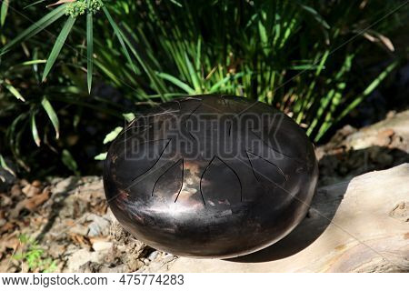 Steel Tongue Drum On Ground Outdoors. Percussion Musical Instrument