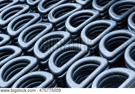 D-shaped Steel Rings Stacked In Close-up. Lots Of Steel Rings For Securing And Securing Heavy Indust