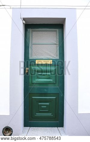 Typical Portuguese Facade With Green Wooden Door On Cobblestone Street In Evora Town, Portugal