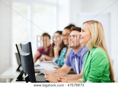 education concept - students with computers studying at school