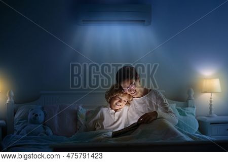Air Conditioner In Bedroom. Kids Room Climate Control. Mother And Child In Bed Under Cool Air Breeze