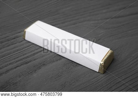 Tasty Chocolate Bar In Package On Grey Wooden Table, Closeup