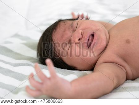 Newborn Baby Crying On White And Grey Striped Blanket Sheet. Infant 1 Month Screaming On Bed. Colic 