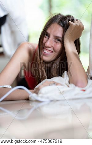 A Young Female Fashion Designer Smiles, Looks At The Camera And Holds Scissors In Her Hands