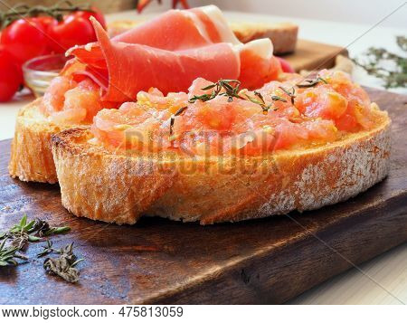 Close-up Of Spanish Tapas On A Wooden Board. Toasted Bread Rubbed With Fresh Garlic And Ripe Tomato 