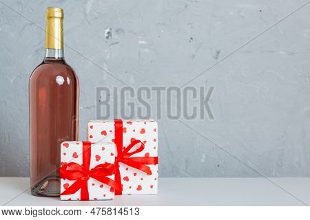 Bottle Of Wine On Colored Background For Valentine Day With Gift Box. Heart Shaped With Presrnt Box 