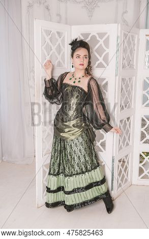 Beautiful Young Smiling Woman Wearing Green Medieval Vintage Victorian Style Dress Stand Near Screen