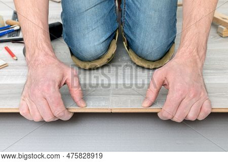 Man Lays Laminate On The Floor, Butt-joining The Boards. Repair And Decoration Of Premises. Modern F