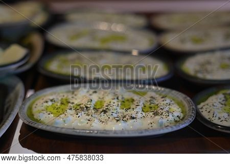 Turkish Appetizer Haydari With Yogurt (tzatziki) In White Plate On Wooden Surface. Selective Focus.
