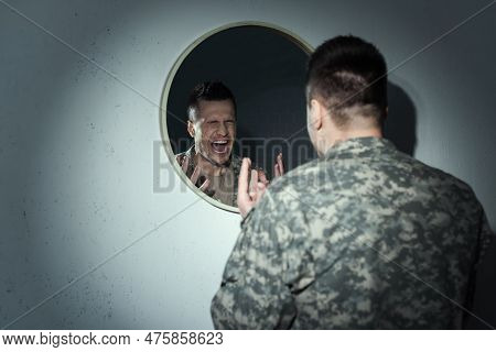 Angry Military Veteran Screaming Near Mirror While Suffering Post Traumatic Stress Disorder.