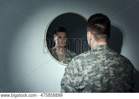 Blurred Military Veteran With Emotional Distress Looking At Mirror At Home.