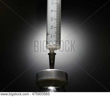5ml Disposable Syringe Injects Needle In A Bottle With Vaccine Isolated On Black Stock Photo