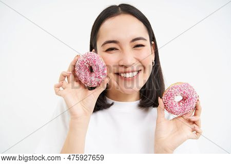 Smiling Korean Woman Eats Pink Glazed Doughnuts, Enjoys Delicious Donnut, Junk Food, Not Care About 