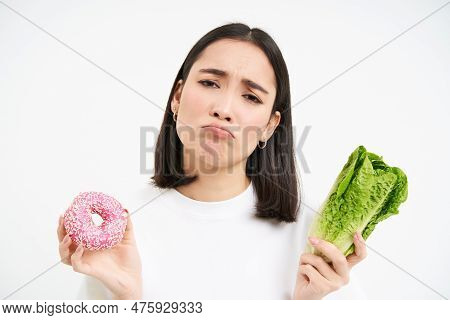 Healthy Clean Detox Eating Concept. Vegetarian, Vegan, Raw Concept. Sad Asian Girl On Diet Holds Dou