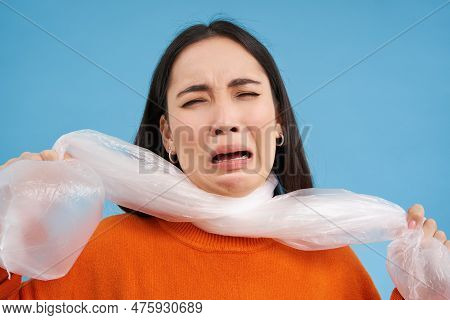 Woman Suffocating, Being Choked By Plastic Bag, Concept Of Ecology, Environment And Recycling, Blue 