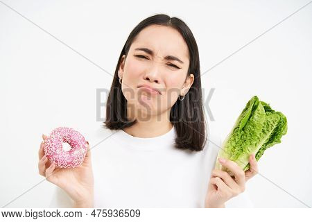 Healthy Clean Detox Eating Concept. Vegetarian, Vegan, Raw Concept. Sad Asian Girl On Diet Holds Dou