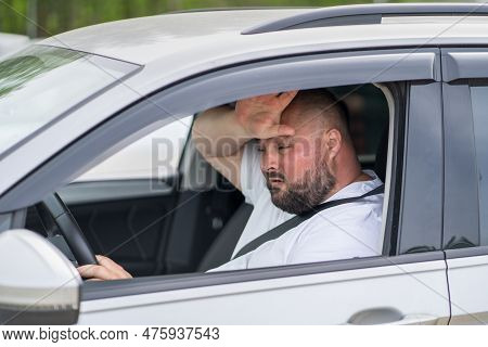Overweight Man Drives In Car Without Air Conditioning In Hot Summer Weather. Male Wiping Sweat From 