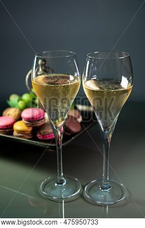 Glasses Of Sparkling White Wine Champagne Or Cava With Bubbles And Sweet Dessert Colorful Macarons B