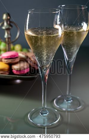 Glasses Of Sparkling White Wine Champagne Or Cava With Bubbles And Sweet Dessert Colorful Macarons B