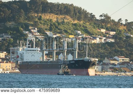 11 April 2023 Lisbon, Portugal: A Large Cargo Ship And A Small Boat Nearby