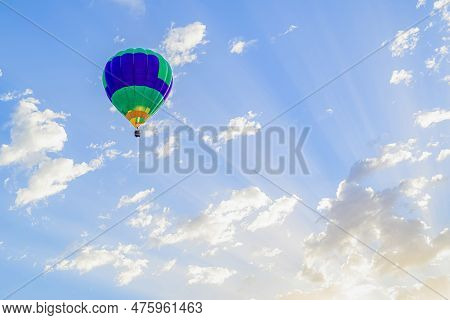 Colorful Hot Air Balloon Flying Over Blue Sky With White Clouds
