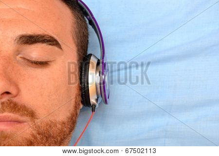 Man with headphones in bed
