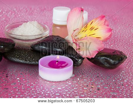 Aromatic oil, salt, candle, stones and flower