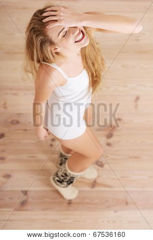 Cheerful, carefree young caucasian woman feels happy. Standing, or dacing, posing over wooden floor.