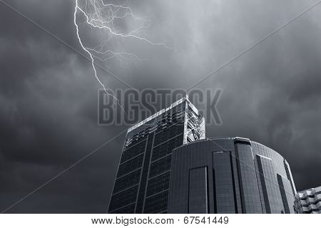 Bottom image of skyscraper with thunder lightning in sky