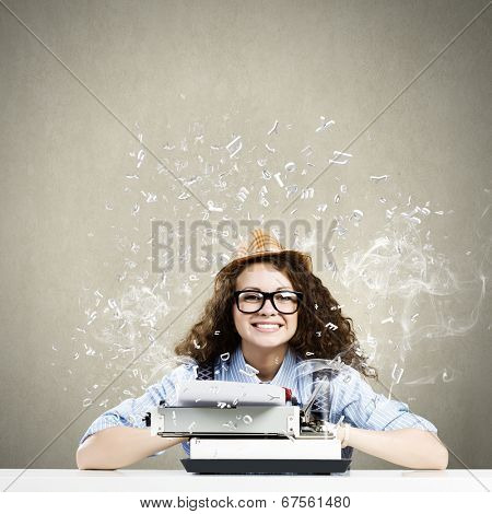 Young funny woman in glasses using typewriter