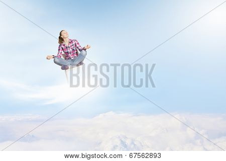 Young woman sitting on chair and meditating