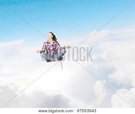 Young woman sitting on chair and meditating