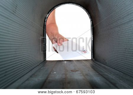 A Unique view of someone getting or placing mail in a mail box, shot from the Inside Out. 