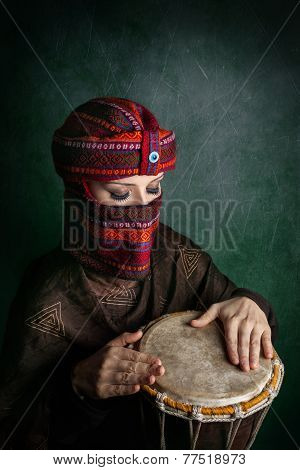Woman In Turban Playing Drum