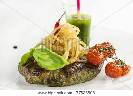 Grilled steak with sauce and greens