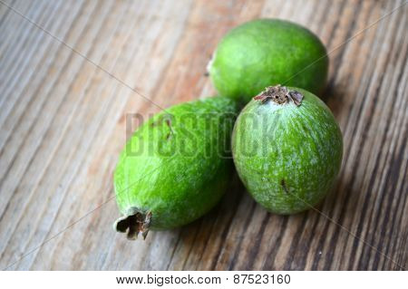 Green feijoa fruit on wooden table