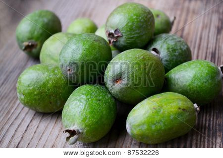 Green feijoa fruit on wooden table