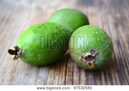 Green feijoa fruit on wooden table