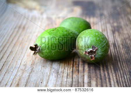 Green feijoa fruit on wooden table