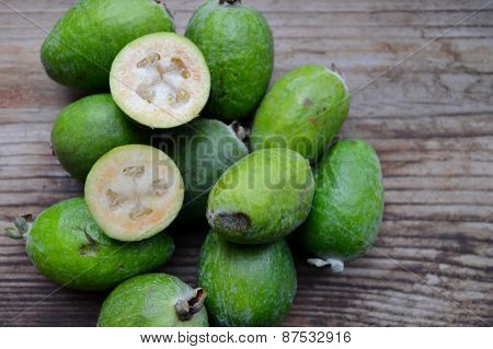 Green feijoa fruit on wooden table