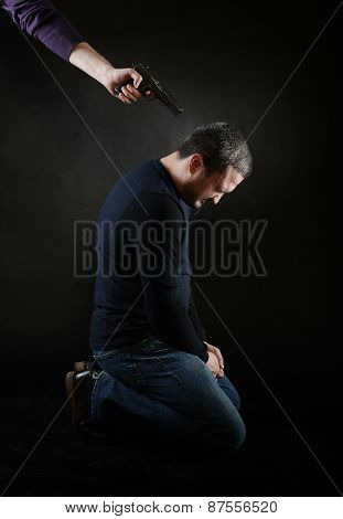 A Man On The Knees Under The Gun